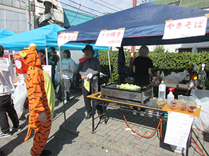 イカ焼き屋台の前にいる南区長 写真